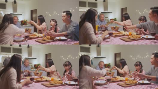 幸福的家庭时间和关系，亚洲大家庭有一个小聚会，一起在家里吃东西。爷爷很高兴看到他的孩子和侄子在家里的餐桌上吃饭，分享食物。高清在线视频素材下载