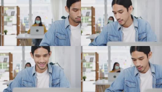 新常态下的亚洲商人社交距离为病毒预防在家庭办公室工作时使用笔记本电脑向同事介绍视频通话计划。高清在线视频素材下载