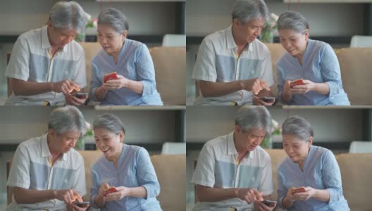 快乐的亚洲华人祖父母使用电话，在客厅愉快地交谈高清在线视频素材下载