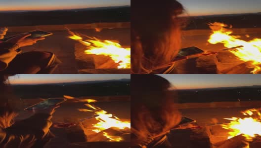 一个女人在火坑里烤棉花糖并拍摄它-移动拍摄高清在线视频素材下载