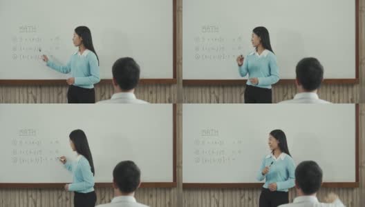 年轻的亚洲教师在教室里教学生。高清在线视频素材下载