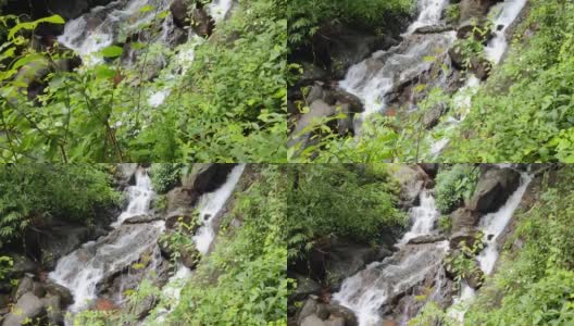 一个壮观的阳光下的瀑布俯瞰着湍急的小溪的悬崖高清在线视频素材下载