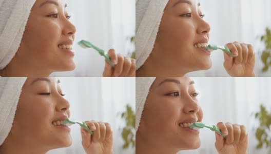 口腔卫生习惯。近肖像年轻积极的亚洲女士刷牙，关心嘴在早晨高清在线视频素材下载