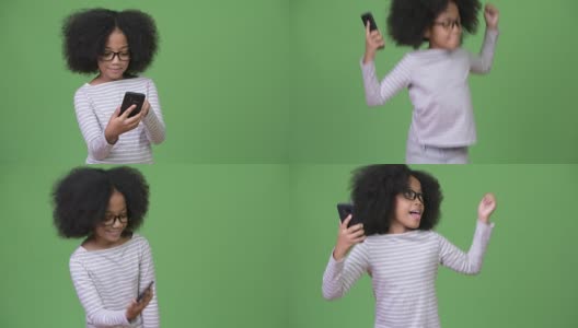 年轻可爱的非洲女孩与非洲发型使用电话和庆祝高清在线视频素材下载