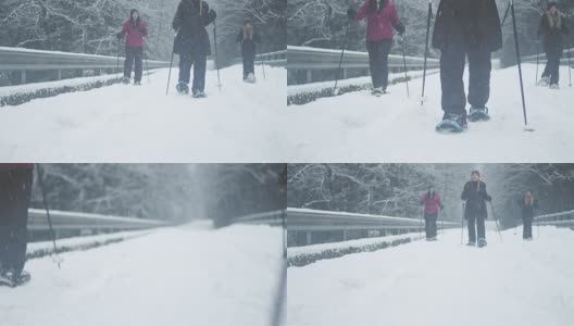 广角镜头，三个年轻的女士徒步走向相机在一个下雪的日子高清在线视频素材下载