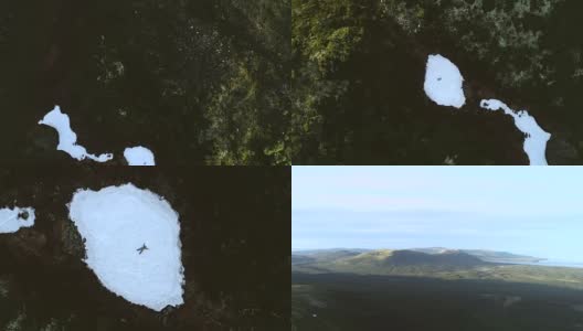 山间的游客躺在白雪覆盖的林间空地上。空中旋转视图高清在线视频素材下载