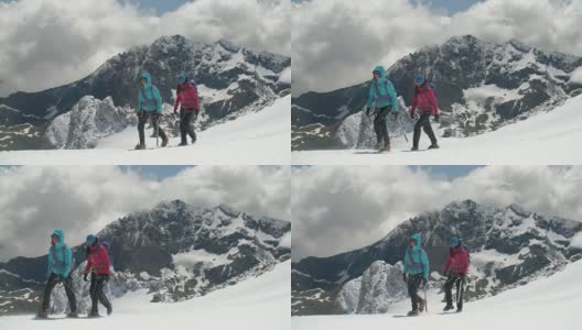 两名女登山运动员穿过高山中的冰川山脊，风暴云正在酝酿。高清在线视频素材下载