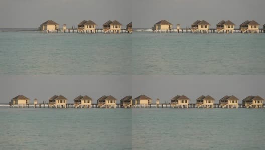 在马尔代夫日出或日落与豪华水上别墅热带泻湖的观点高清在线视频素材下载