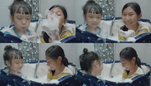 快乐的亚洲孩子们在塑料浴缸里一起吹泡泡，生活理念。高清在线视频素材下载