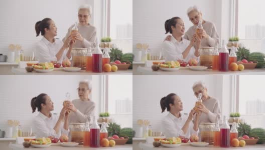母亲好奇地问亚洲大四女儿，如何自制不同口味的发酵生康普茶。在厨房里提供健康的天然益生菌调味饮料高清在线视频素材下载