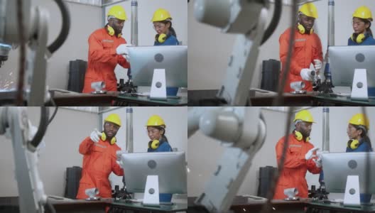 多种族的工程师在工厂工作，用电脑和平板检查焊接机器人手臂。经理工程师检查和控制仓库自动化机器人手臂机器高清在线视频素材下载