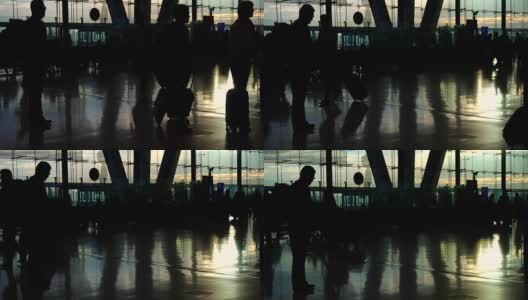 在机场，人群的剪影与晨光玻璃建筑形成对比高清在线视频素材下载