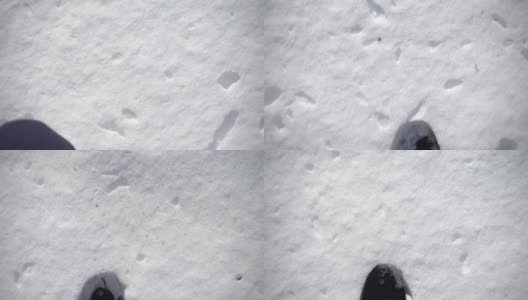 第一个人看到一个人穿着黑靴子走在雪地里。在厚厚的雪地上留下足迹。高清在线视频素材下载