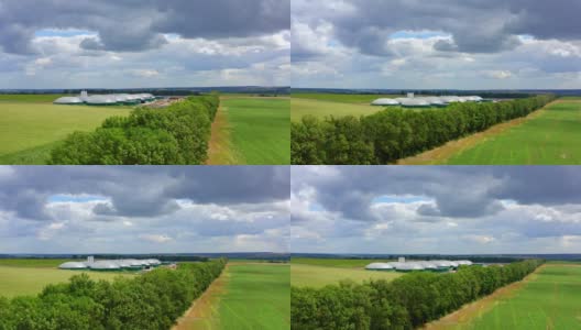 田间沼气厂。有机农场在黑暗多云的天空下被夏日的绿色大自然包围着。沼气是通过发酵生物质而产生的。高清在线视频素材下载