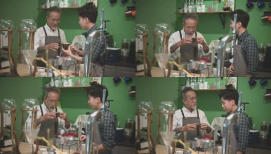 亚洲华人资深男咖啡师老板在他的咖啡厅吧台品尝教练的拿铁咖啡时很满意高清在线视频素材下载