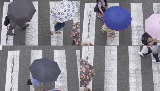 头顶拍摄的行人在雨中撑着彩色雨伞，慢镜头高清在线视频素材下载