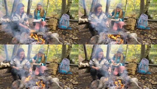 女性朋友在户外露营时在篝火上做传统煎饼高清在线视频素材下载