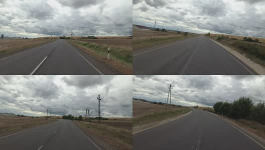 一个骑摩托车的人在雨天沿着沙漠中的道路行驶。第一人称视角高清在线视频素材下载