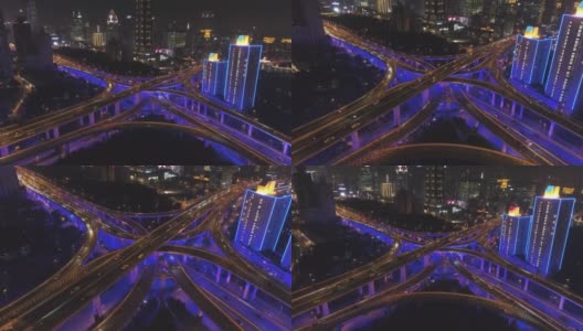 夜间蓝色照明高架路立交桥。上海,中国。鸟瞰图。无人机向前飞行，摄像头向下倾斜。远景。高清在线视频素材下载