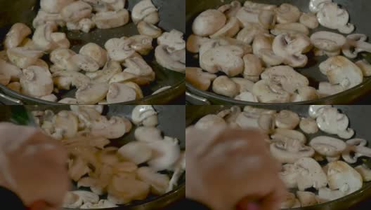 特写:一只手在煎锅中搅拌白蘑菇高清在线视频素材下载