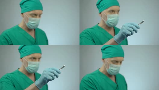 专注的男性外科医生手持锋利的手术刀，点头开始手术高清在线视频素材下载