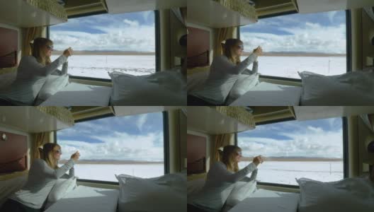 近距离观察:一名女子在火车上拍摄西藏雪景。高清在线视频素材下载