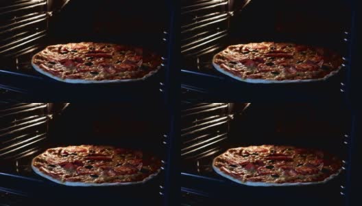 从烤箱内部看。用电热对流烤箱烹制意大利披萨。特写的披萨上面有西红柿，橄榄，马苏里拉火腿和奶酪。披萨奶酪融化冒泡。间隔拍摄。高清在线视频素材下载