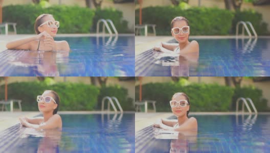 年轻的亚洲女人放松愉快周围的室外游泳池高清在线视频素材下载