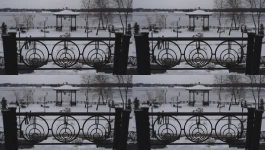 公园下着雪，映衬着结冰的河面，孤独的人慢慢地走着高清在线视频素材下载