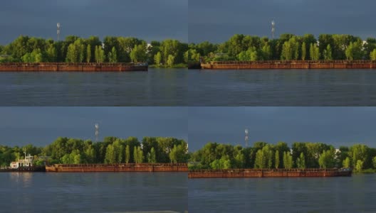 驳船，一艘货船沿河航行，沿岸绿树成荫。水路运输的概念高清在线视频素材下载