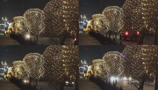 街道两旁的树上、圣诞花环灯和交通道路上的汽车上的夜间装饰照明高清在线视频素材下载
