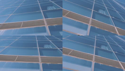 城市摩天楼商业中心在巴塞罗那。办公大楼上现代建筑窗户的几何形状细节。摩天大楼的天空背景。看了。底部视图。多莉拍摄高清在线视频素材下载