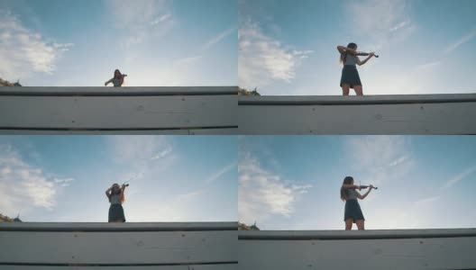 在夏日的蓝天下，年轻女子拉着小提琴高清在线视频素材下载