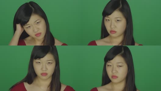 一个年轻的亚洲女人看起来生气和恼怒，在一个绿色屏幕的工作室背景高清在线视频素材下载