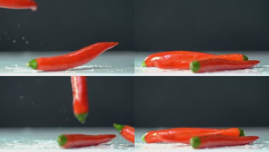 特写红辣椒落在白色地板上，黑色背景，慢镜头。高清在线视频素材下载