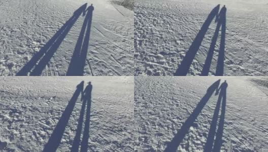 浪漫的情侣手牵着手走在雪地上的影子高清在线视频素材下载