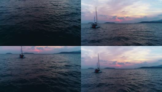 孤独的游艇，双体帆船在夕阳西下的海面上航行。高清在线视频素材下载