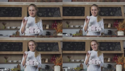 美丽的女面包师拿着一盘棉花糖对着镜头微笑高清在线视频素材下载