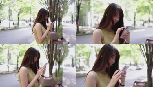 穿着黄色衣服的漂亮女人在城市里使用智能手机高清在线视频素材下载
