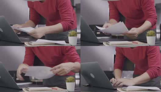 (特写)迷人的亚洲男人企业家早上在家工作的时候打开笔记本电脑，开始做他的创新项目。他正在使用笔记本电脑，研究，电子邮件。国内业务高清在线视频素材下载
