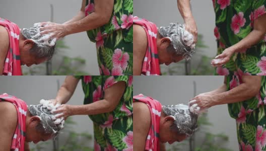 亚洲华人老年妇女洗她的丈夫的头发，洗头在前院当没有水供应高清在线视频素材下载