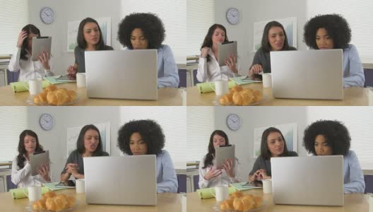 两名商务女性在使用笔记本电脑，同事在整理头发高清在线视频素材下载