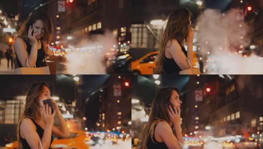 在美国纽约，年轻快乐的女人晚上拿着包站在市中心的车流中打电话高清在线视频素材下载