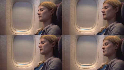 乱流时睡在飞机窗边的漂亮女人。长途飞行。摇摇欲坠的形象高清在线视频素材下载