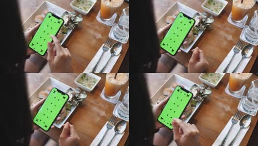 一名女子在绿色屏幕的餐厅使用智能手机高清在线视频素材下载