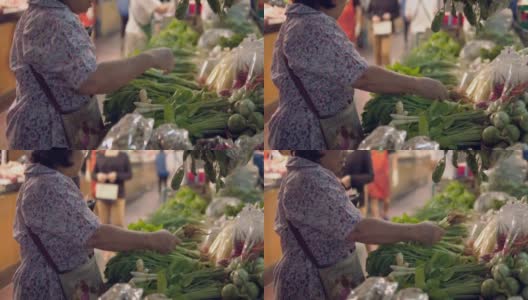 购买水果和蔬菜的资深亚洲妇女站在农贸市场高清在线视频素材下载