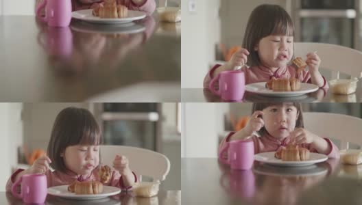 蹒跚学步的女孩在吃月饼高清在线视频素材下载