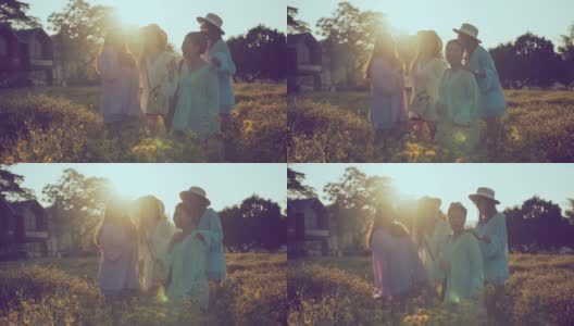 太阳耀光射线与亚洲女性朋友群笑笑快乐的一起旅行站在黄花花园农场自然的背景理念交谈高清在线视频素材下载