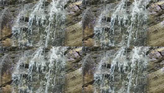 近距离观看奥地利卡林西亚的马尔塔塔尔瀑布。水在非常陡峭的岩石上下沉。山坡上长满了灌木和草。晴朗晴朗的一天。自然的力量高清在线视频素材下载