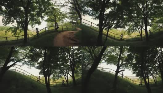 公园里跑着两个女孩，侧视图，两个运动员晨跑，城市视图，在筏子附近跑着，城市背景上跑着两个十几岁的女孩高清在线视频素材下载